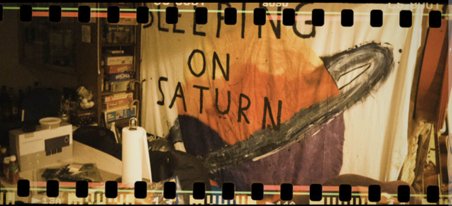 Arits photo for sleeping on saturn, its a tapestry in a room with saturn on the tapestry. 